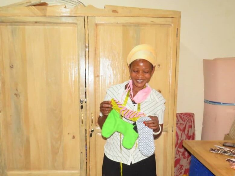 Eine Teilnehmerin des Projekts von Kwizera in Uganda präsentiert eine Hela Stoffbinde
